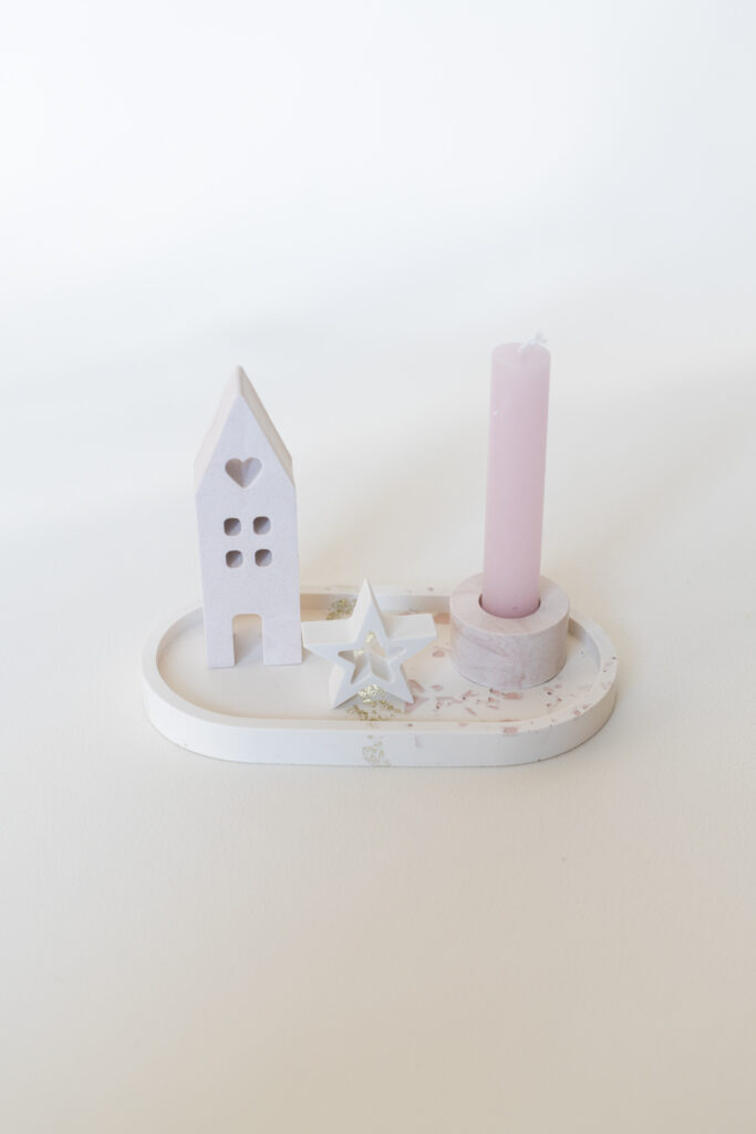 Kleine Jesmonite kaarsenhouder met een wit huisje en een roze kaars, gemaakt bij een workshop in Haaksbergen